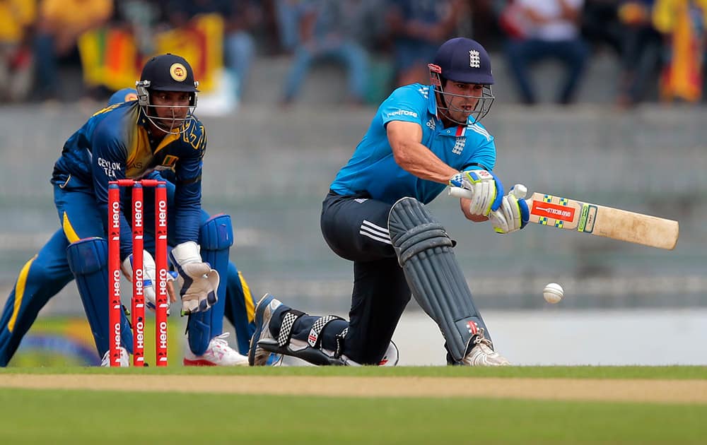 England's captain Alastair Cook plays a shot as Sri Lankan wicketkeeper Kumar Sangakkara watches during the second one-day international cricket match in Colombo, Sri Lanka.