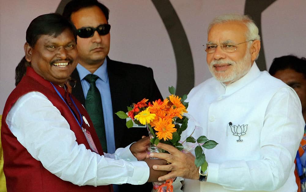 Prime Minister Narendra Modi is greeted by BJP leader Arjun Munda at an election rally in Jamshedpur.