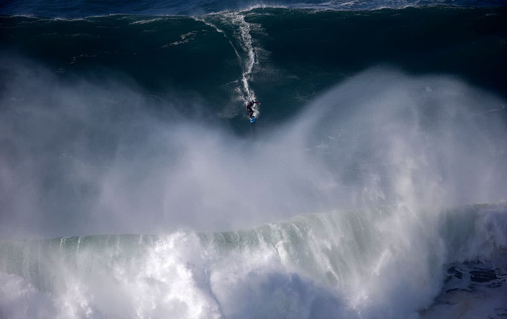 A surfer rides a big wave during a tow-in surfing session at the Praia do Norte or North beach, in Nazare, Portugal.