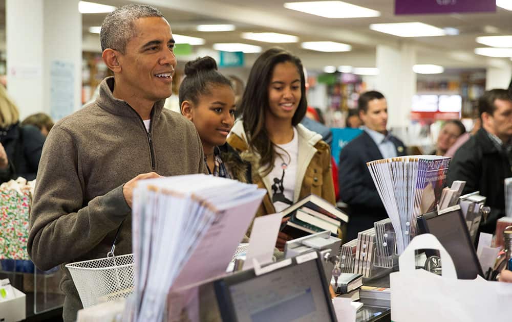 President Barack Obama, left, shops with his daughters, Sasha, center, and Malia, at Politics and Prose bookstore for 