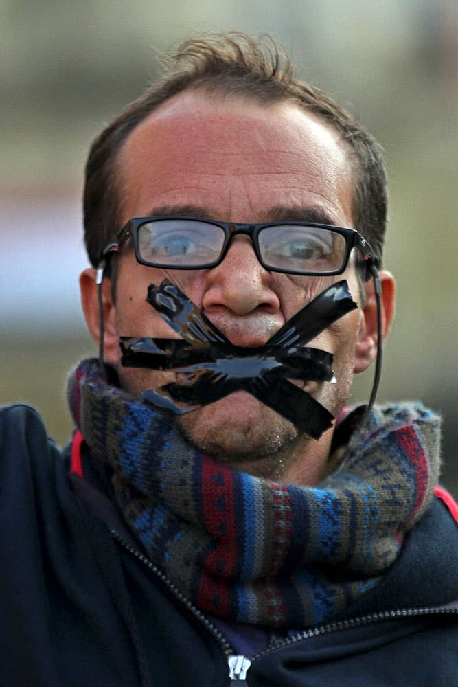 A protester tapes his mouth closed during a demonstration after a judge on Saturday dismissed the case against former President Hosni Mubarak and acquitted his security chief over the killing of protesters during Egypt’s 2011 uprising, near Tahrir Square, Cairo, Egypt,