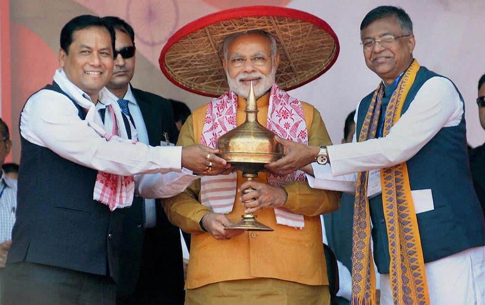 Prime Minister Narendra Modi being felicitated with Traditional Assamese Japi, Gamocha and Sarai by Union Minister of State for Sports and Youth Affairs Sarbananda Sonowal (L) and Siddharth Bhattacharya State President BJP during the BJP workers meet in Guwahati.