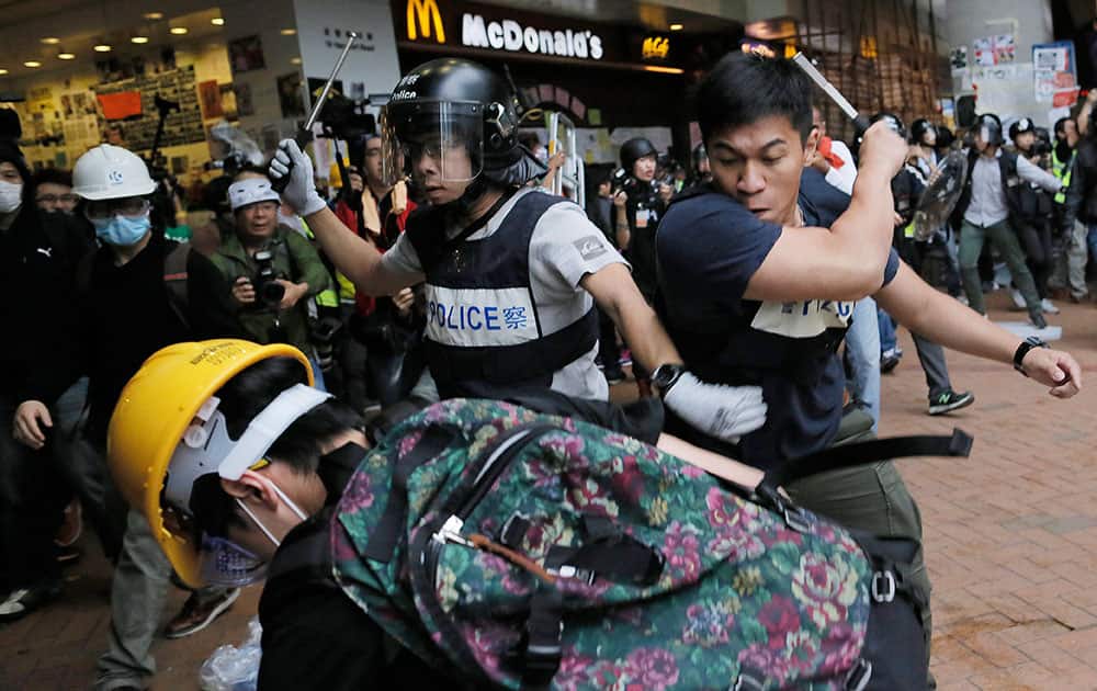 Police officers beat up protesters as they try to disperse them outside government headquarters in Hong Kong.