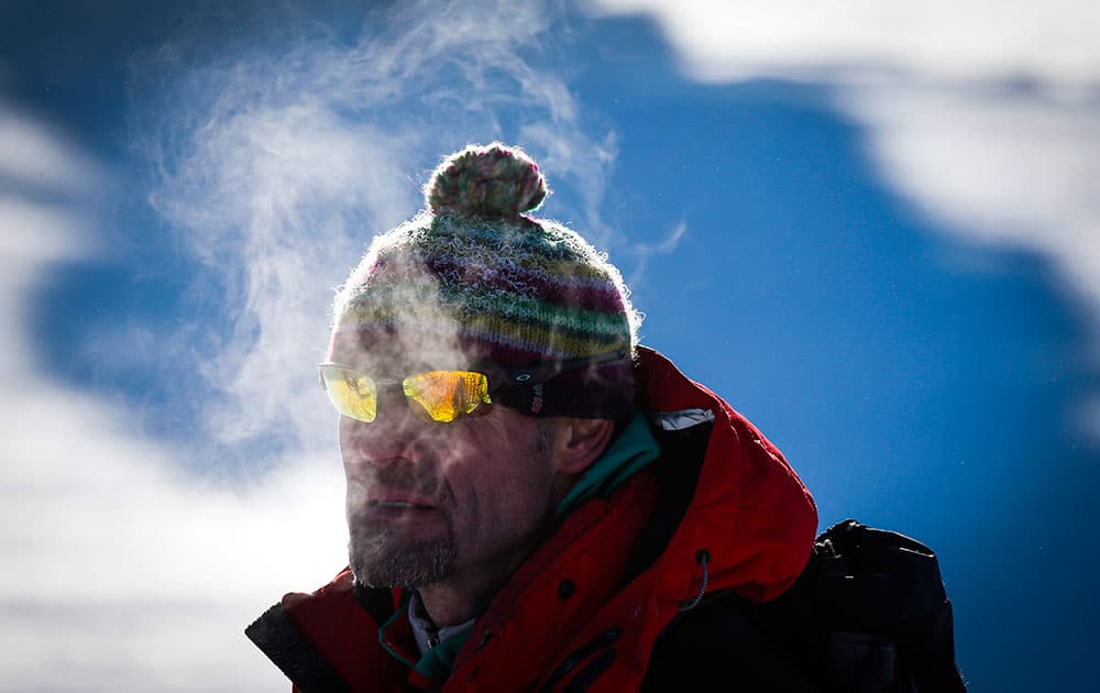 A course worker looks on in frigid temperatures at the men's World Cup Super-G ski race in Lake Louise, Alberta.