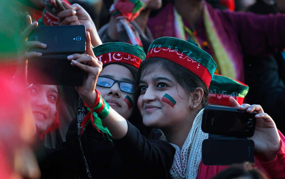 Young supporters of Pakistani politician Imran Khan take their picture with a mobile phone during an anti-government rally in Islamabad, Pakistan.