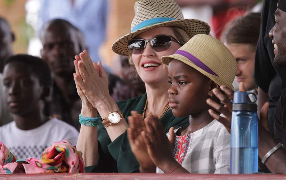 US singer Madonna claps hands with her daughter Mercy, right, in Kasungu, about 150 kilometers north of the capital Lilongwe.