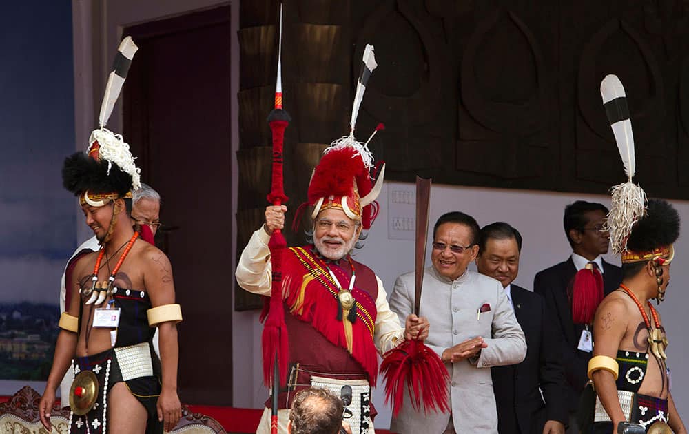 Indian Prime Minister Narendra Modi, center, in traditional attire holds a Naga spear and a sword during the inaugural ceremony of the Hornbill Festival in Kisama village in Nagaland.