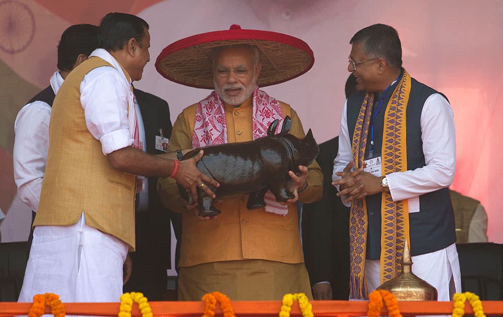Indian Prime Minister Narendra Modi, center, is presented with a statue of a one-horned Rhino by Bharatiya Janata Party (BJP) workers at a rally in Gauhati.