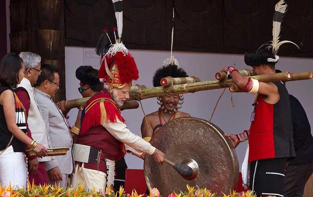 Indian Prime Minister Narendra Modi, third right, dressed in Naga attire hits a traditional musical instrument to inaugurate the Hornbill festival in Kisama village in Nagaland.