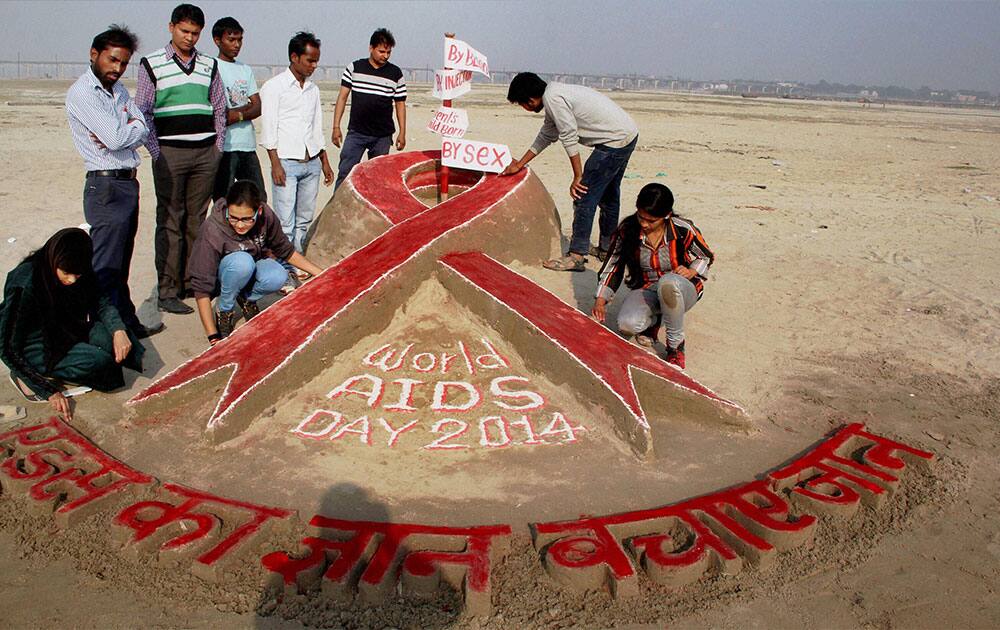STUDENTS OF ALLAHABAD UNIVERSITY CREATE SAND ART TO RAISE AWARENESS ON AIDS ON THE EVE OF WORLD AIDS DAY, ON THE BANKS OF THE GANGA RIVER IN ALLAHABAD.