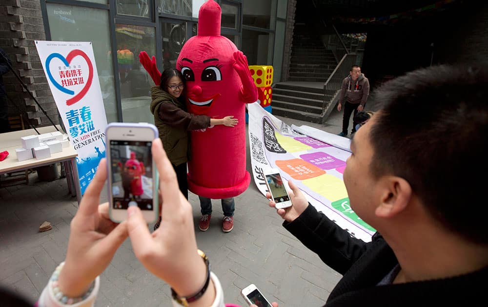 A participant hugs a condom mascot during an event to promote awareness of HIV testing ahead of the Dec 1 World AIDS day in Beijing.