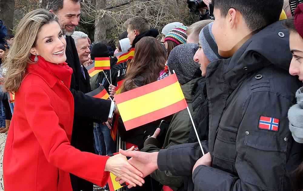 Queen Letizia, her husband King of Spain, Felipe VI, and German President Joachim Gauck, from left, shake hands with students in the garden of Bellevue palace in Berlin, Germany.