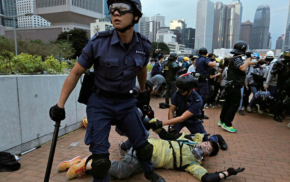A protester is arrested by police officers outside government headquarters in Hong Kong as pro-democracy protesters try to surround the headquarters, stepping up their movement for genuine democratic reforms after camping out on the city's streets for more than two months.