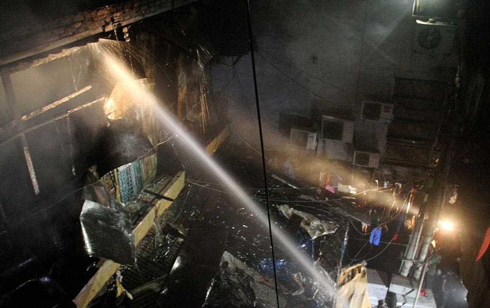 Fire Fighter trying to douse the flame at the cotton market , Sadar Bazar in New Delhi.
