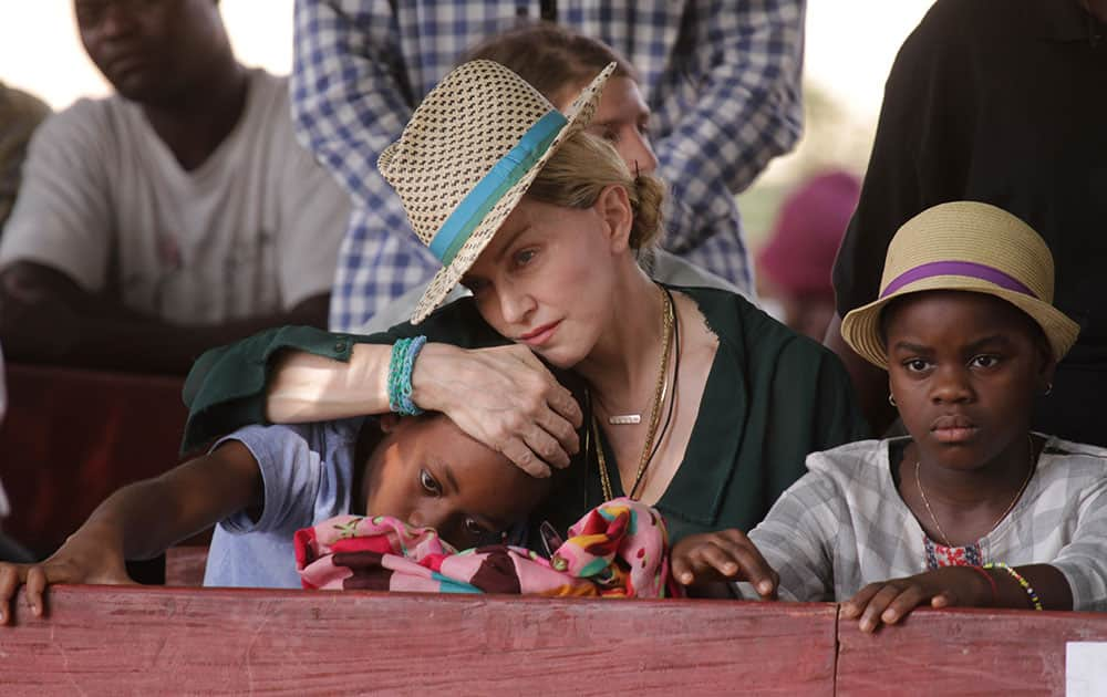 US singer Madonna hugs her son David, left, while her daughter Mercy looks on in Kasungu, about 150 kilometers north of the capital Lilongwe.