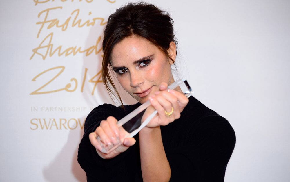 Designer Victoria Beckham poses for photographers with her Best Brand award at The British Fashion Awards 2014, in London.