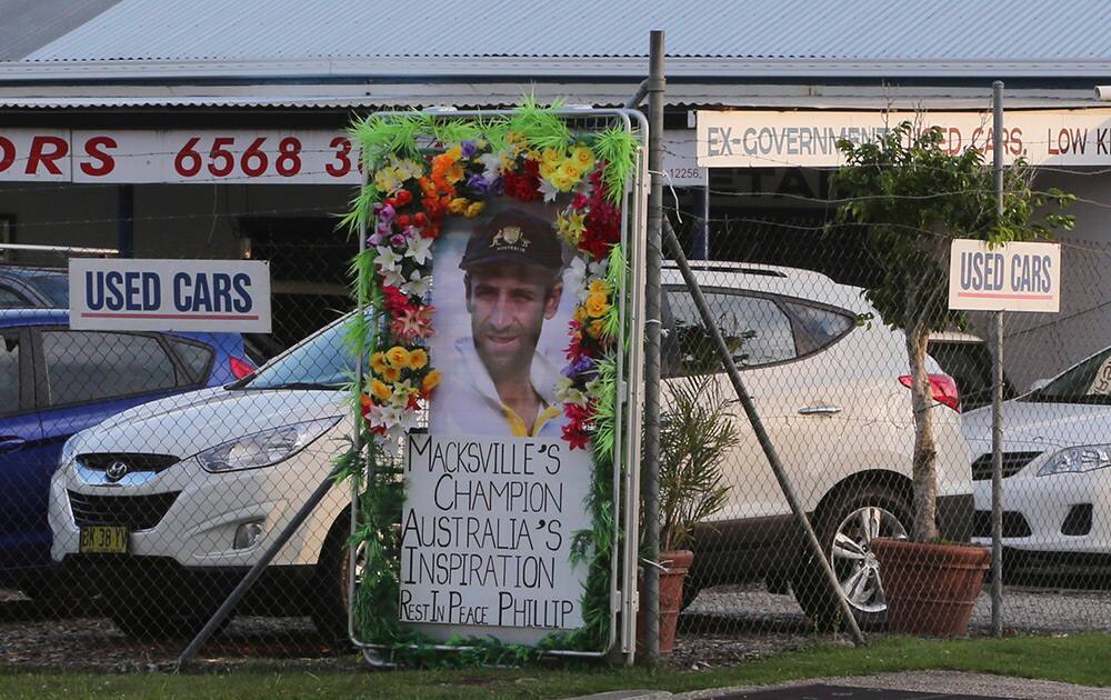 A tribute banner is attached on a fence of an auto dealership in the hometown of Australian cricket player Phillip Hughes in Macksville, Australia.