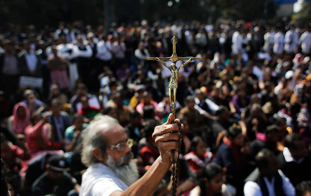 An elderly Christian holds high a crucifix during a protest after a fire destroyed a church on Monday, outside Delhi police headquarters in New Delhi. While the cause of the fire is not known, the Delhi Catholic Archdiocese said Tuesday that 