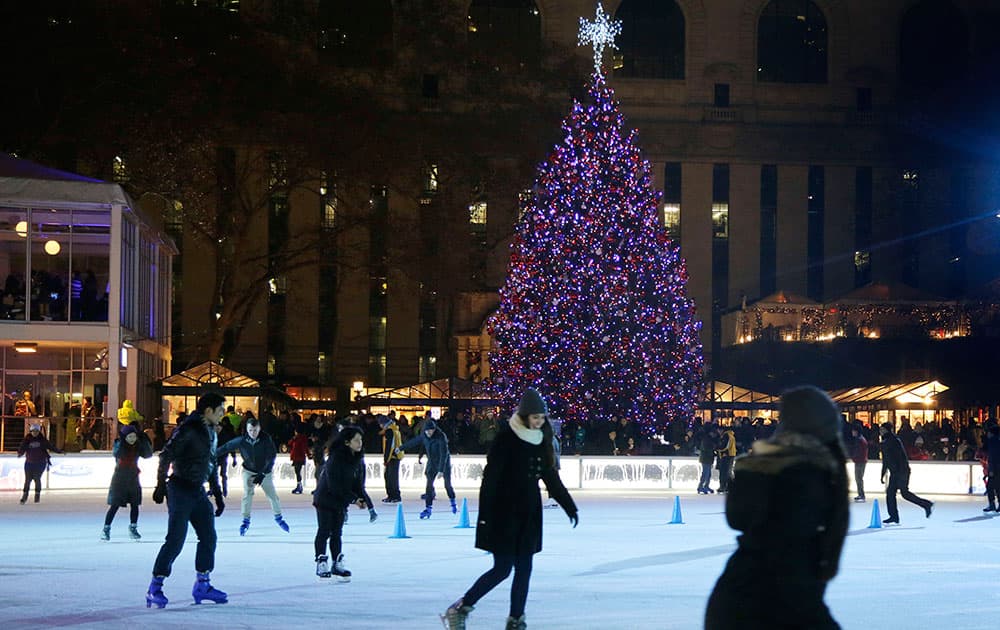 Skaters glide around the ice rink immediately after a Christmas tree lighting ceremony at Winter Village at Bryant Park, in New York.