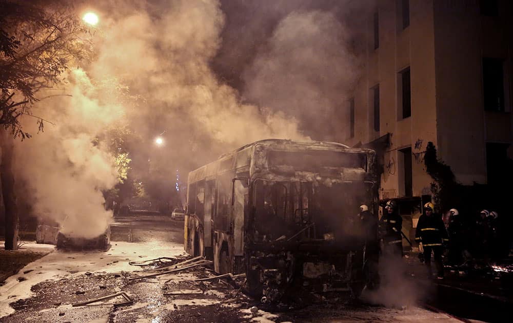 Firemen try to extinguish a bus and a car during clashes between anarchists and police in central Athens.