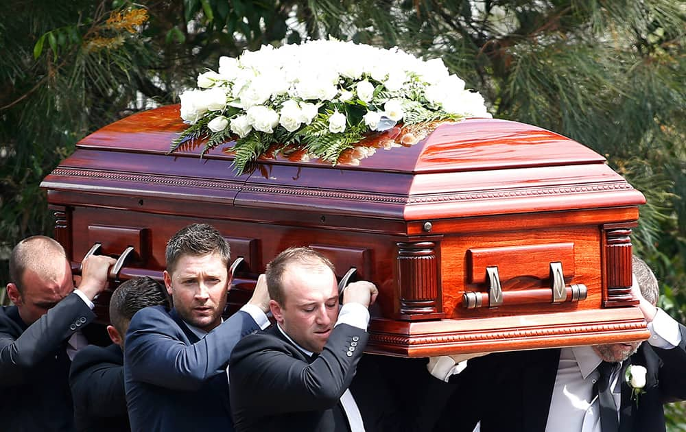 Australian cricket captain Michael Clarke, helps carry the coffin of Phillip Hughes in Macksville, Australia