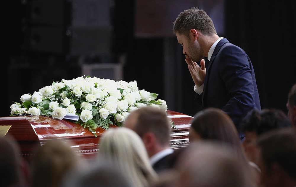 Australian cricket captain Michael Clarke pays his respect to Phillip Hughes at his coffin during his funeral in Macksville, Australia.