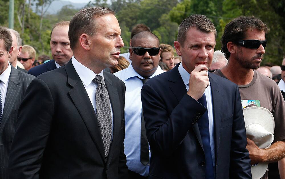 Australian Prime Minister Tony Abbott, talks to New South Wales Premier Mike Baird, following the funeral service for Phillip Hughes in Macksville, Australia.