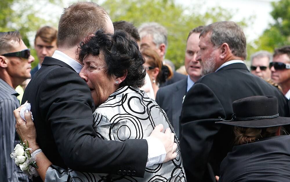 Virgina Hughes is comforted by her son, Jason, following the funeral of her other son Phillip in Macksville, Australia.