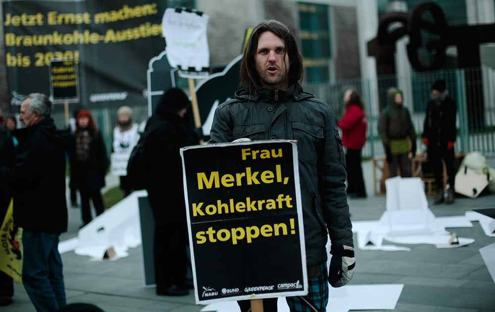 A protestor holds a poster reading 