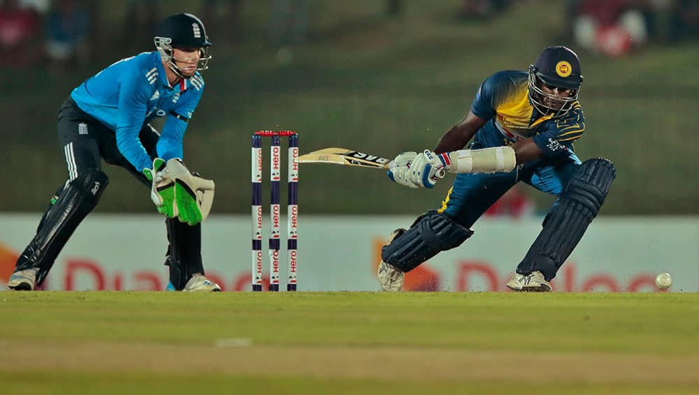 England's wicketkeeper Jos Buttler watches as Sri Lanka's Angelo Mathews plays a shot during the third one day international cricket match between them in Hambantota, Sri Lanka.