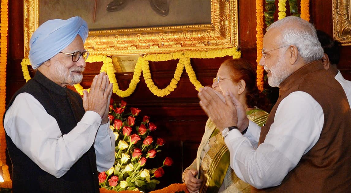 Prime Minister Narendra Modi and former PM Manmohan Singh exchange greetings during a function organised to mark the birth anniversary of Rajendra Prasad, the first President of India, at Parliament House in New Delhi.