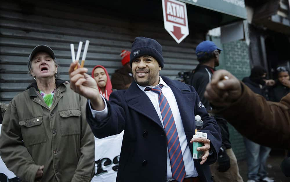 Daniel Skelton holds up loose cigarettes while protesting the grand jury's decision in the Eric Garner case in the borough of Staten Island in New York.