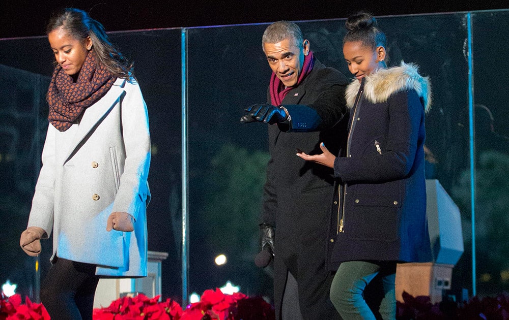 President Barack Obama walks off stage with daughters Malia and Sasha, after participating in the National Christmas Tree lighting ceremony.