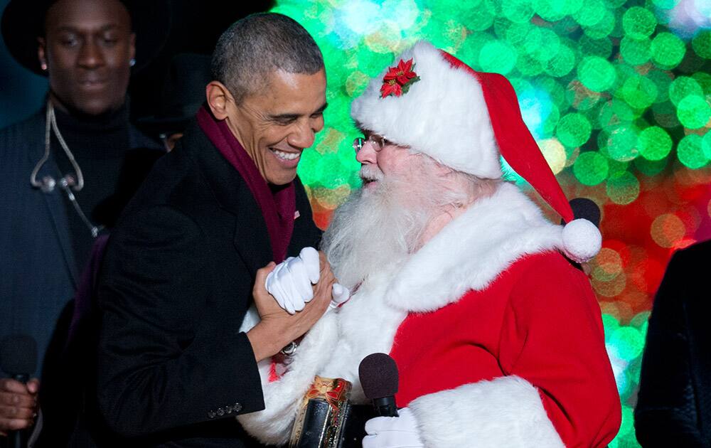 President Barack Obama greets Santa on stage during the National Christmas Tree lighting ceremony at the Ellipse near the White House in Washington.