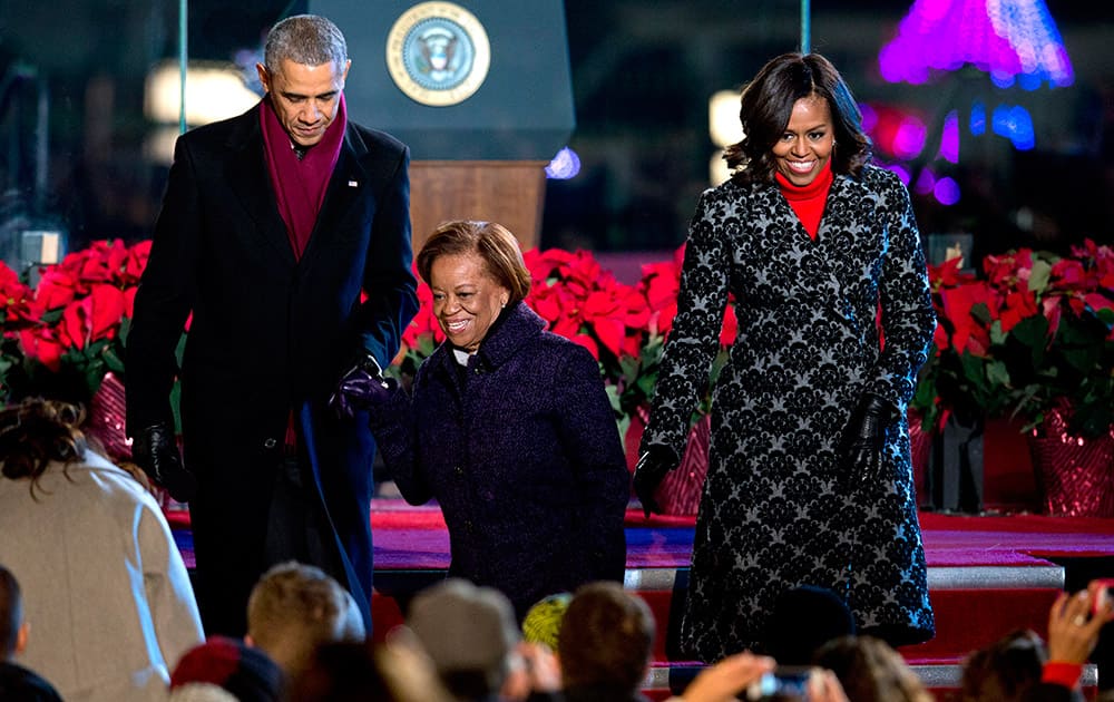 President Barack Obama and first lady Michelle Obama, help Michelle's mother, Marian Robinson, to her seat after lighting the 2014 National Christmas Tree during the National Christmas Tree lighting ceremony at the Ellipse near the White House in Washington.