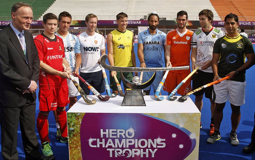 Captains of Hero Hockey Champions Trophy 2014 participating teams, pose for photographs near the champions trophy during its unveiling ceremony at Kalinga stadium in the eastern Indian city of Bhubaneswar.