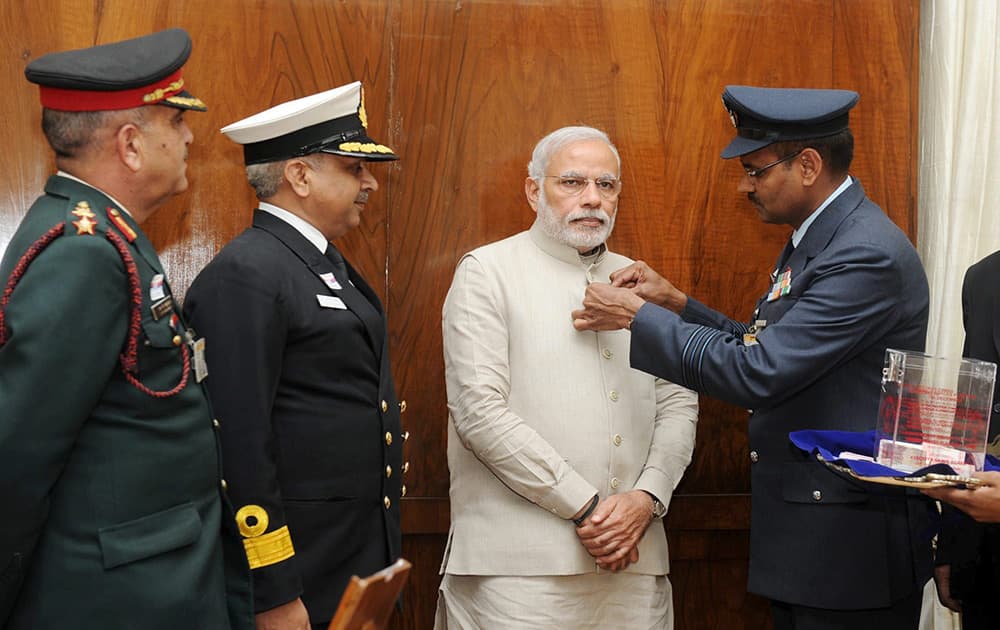 Officers of the Kendriya Sainik Board pinning a flag on the Prime Minister Narendra Modi during the Armed Forces Flag Day in New Delhi.