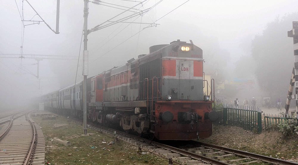 Train runs through a foggy morning.