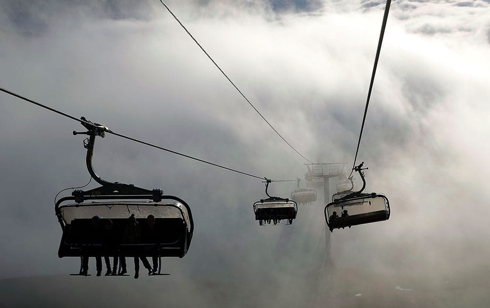 Tourists use chairlifts to reach the summits over the cloud cover in the South Eastern French ski resort of l' Alpe d'Huez. Cold weather and new snow in the forecast has allowed for the resort to open its upper slopes to ski fanatics.