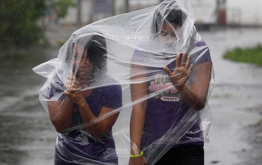 Filipino residents use plastic sheets to protect them from rains and strong winds brought by Typhoon Hagupit in Legazpi, Albay province, eastern Philippines.