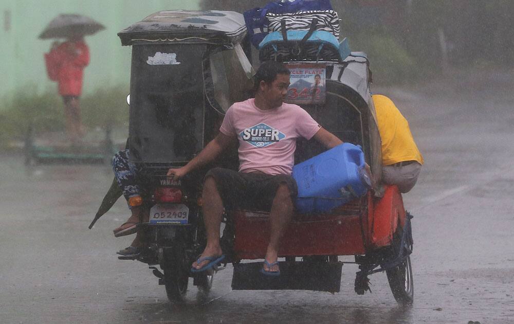 A resident rides a tricycle on their way to an evacuation center as strong winds and rains from Typhoon Hagupit hit Legazpi, Albay province, eastern Philippines.