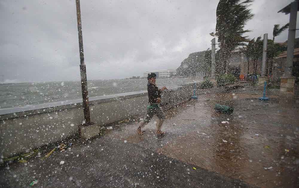 A man reacts as he strong winds and rain from Typhoon Hagupit hit shore in Legazpi, Albay province, eastern Philippines. Haunted by Typhoon Haiyan's massive devastation last year, more than 600,000 people fled Philippine villages and the military went on full alert Saturday to brace for a powerful storm only hours away from the country's eastern coast. 