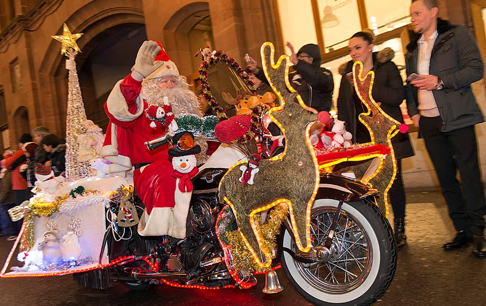 A Harley Davidson motorcyclist from the Harley Owner Group (HOG) Northwest Chapter Switzerland, wearing Santa Claus costumes drives through the streets of Basel, Switzerland.