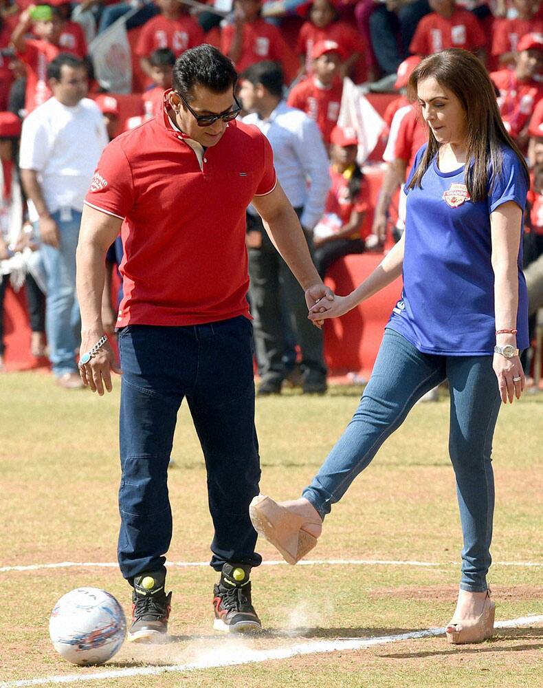 Chairman of Dhirubhai Ambani Foundation, Nita Ambani with Bollywood actor Salman Khan, takes a shot during the launch of Young Champs in Mumbai.