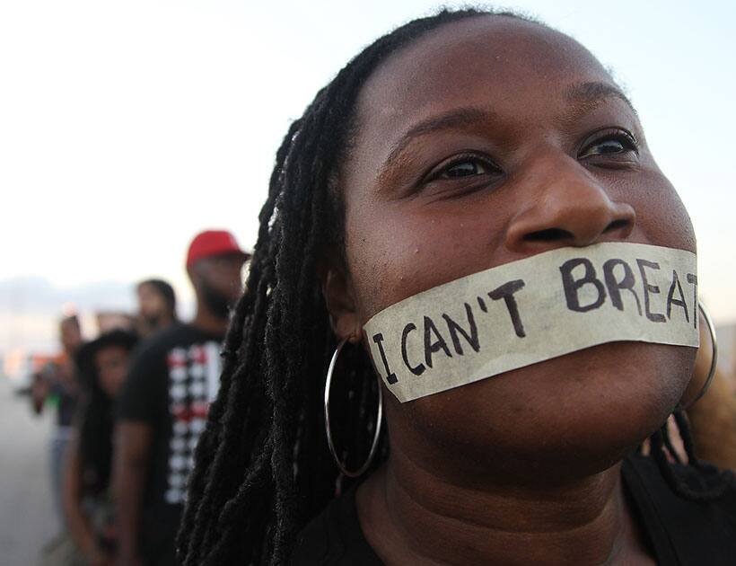 A protestor tapes her mouth with the words 