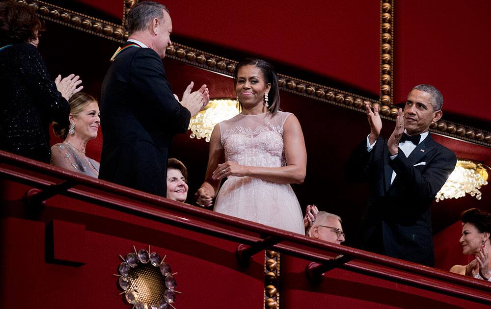 President Barack Obama, right and first lady Michelle Obama, and 2014 Kennedy Center Honors recipients comedienne Lily Tomlin, from left, and actor and filmmaker Tom Hanks, applaud during the Kennedy Center Honors Gala at the Kennedy Center in Washington.