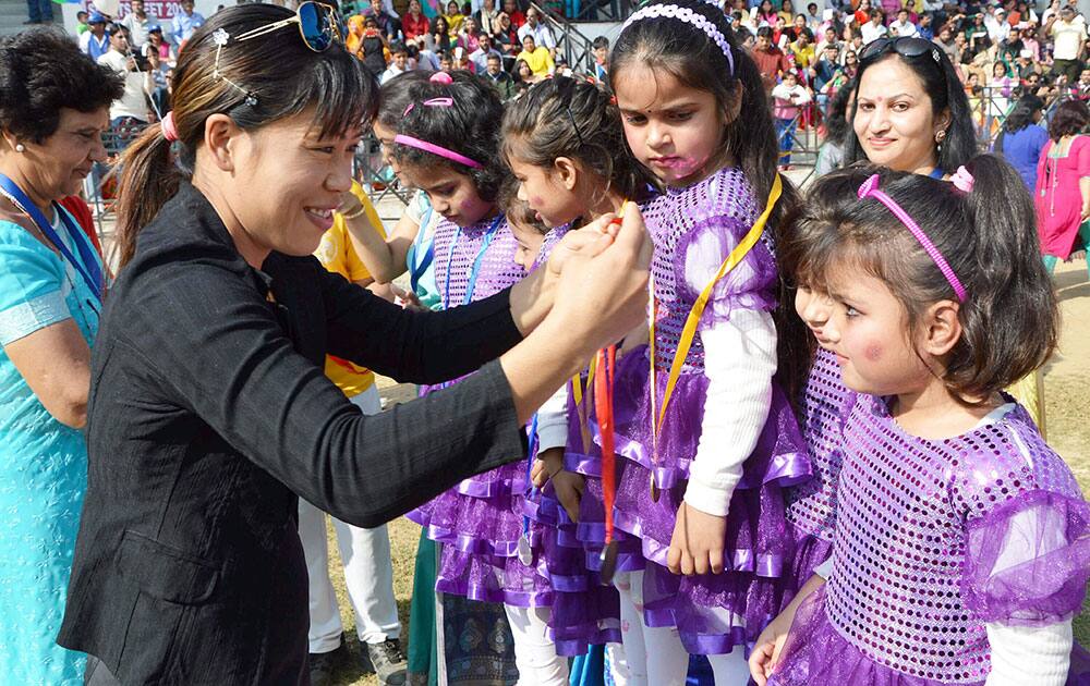 Olympic Bronze medalist M C Mary Kom distributes prize to children of a local school, in Gurgaon.