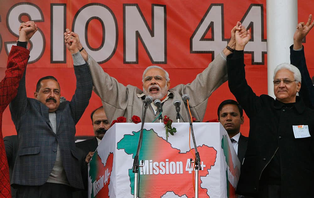 Indian Prime Minister Narendra Modi holding hands with his party leaders shouts slogans during a campaign rally ahead of local elections in Srinagar, Indian controlled Kashmir.