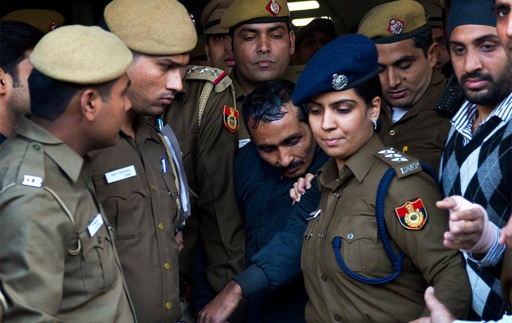 32-year-old Shiv Kumar Yadav, center, a driver from the international taxi-booking service Uber, is surrounded by police as he is brought out after being produced in a court in New Delhi, India.