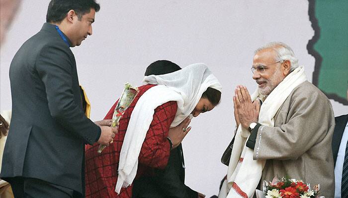 Prime Minister Narendra Modi exchanges greetings with party candidate Hina Bhat during an election rally at Sher-i-Kashmir Cricket Stadium in Srinagar.